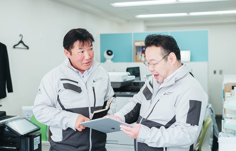 タブレットを見ながら相談するスタッフ