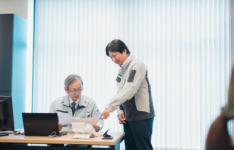 書類を確認しながら相談するスタッフ